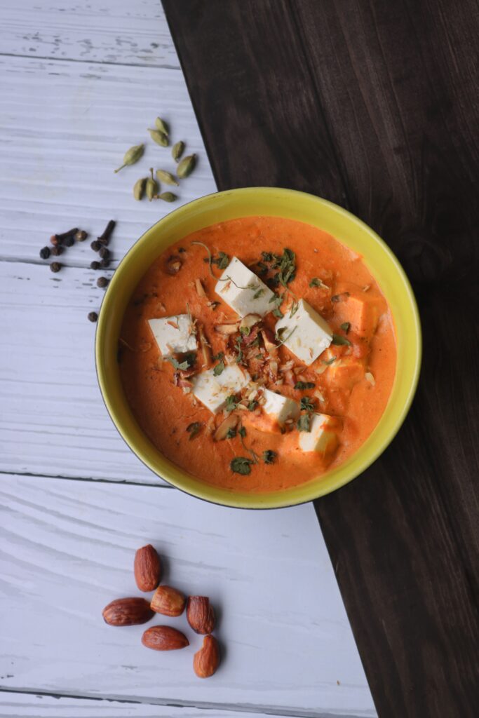 Top view of creamy Indian paneer curry with spices. Perfect for food photography and culinary inspiration.